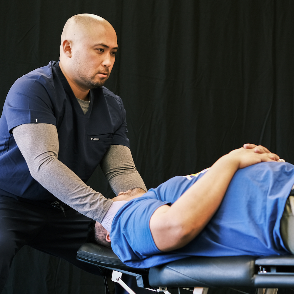 Dr. Jerald Chavez giving patient neck pain treatment